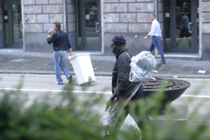 Black umbrella vendor pacing down in Via XXV Aprile