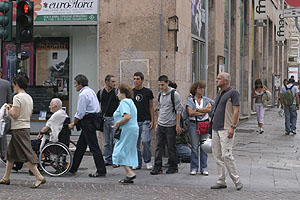 Pedestrians crossing Via XX Settembre into a side street, possibly Via D. Fiasella.