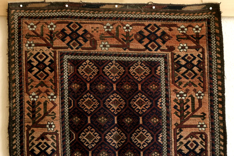 Baluch rug, wide meandering tree border with blossoms, top half